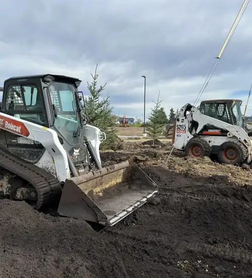 Skid steers performing commercial landscaping construction and property maintenance in Edmonton.