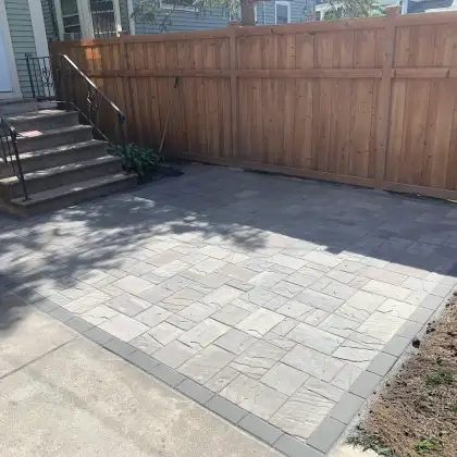 Finished paving stone patio and walkway installed in an Edmonton backyard.