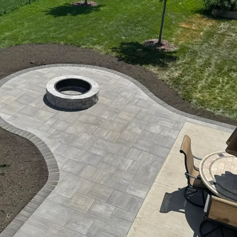 Custom paving stone patio with fire pit and landscape design in Edmonton.