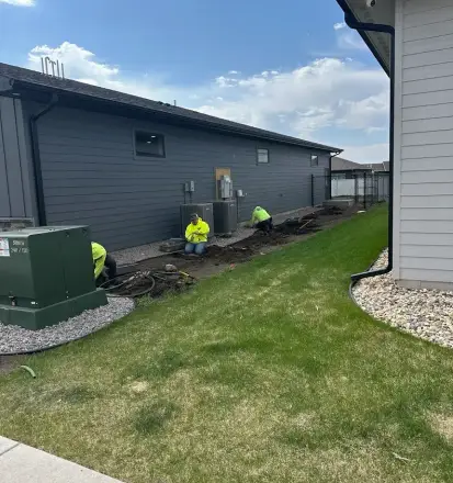 Landscaping construction crew installing fresh sod and completing final grading in Edmonton.