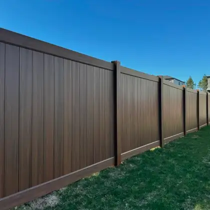 Modern dark brown vinyl privacy fence installed in Riverbend alongside a well-maintained lawn.