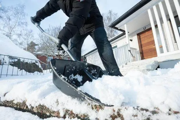 Clearing snow from a residential walk in Edmonton within the bylaw deadline